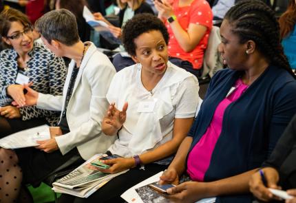 Two black women talking at event 