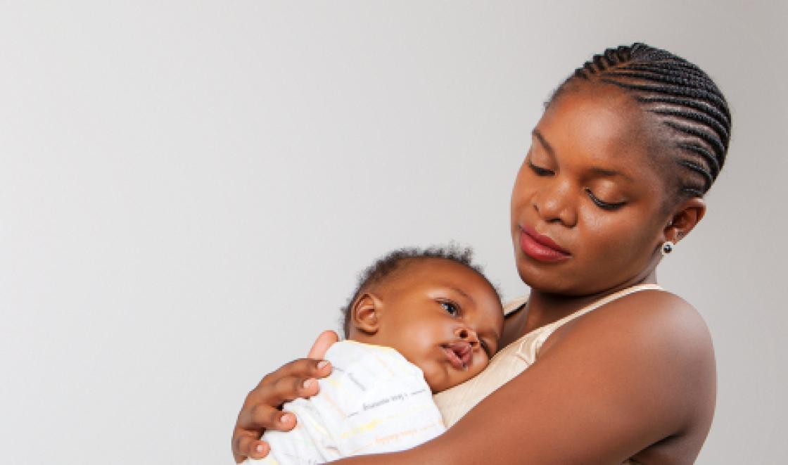 A Black mother holding her baby 