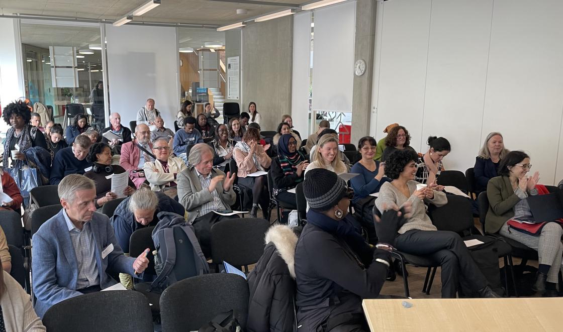 Attendees listening and applauding in a conference space