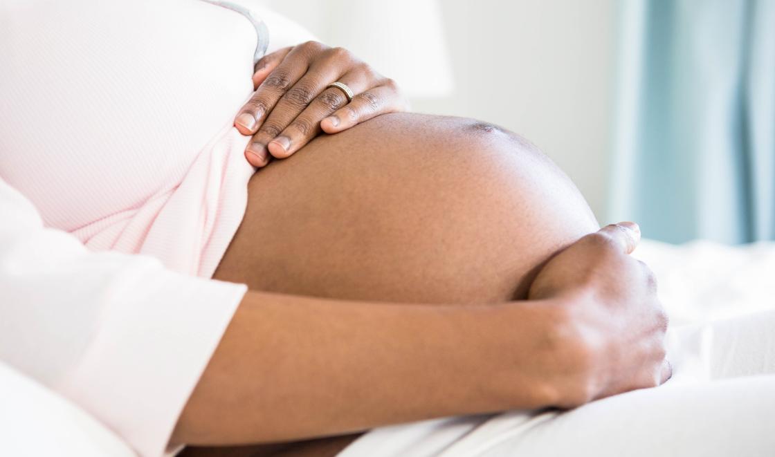 Black pregnant woman holding stomach