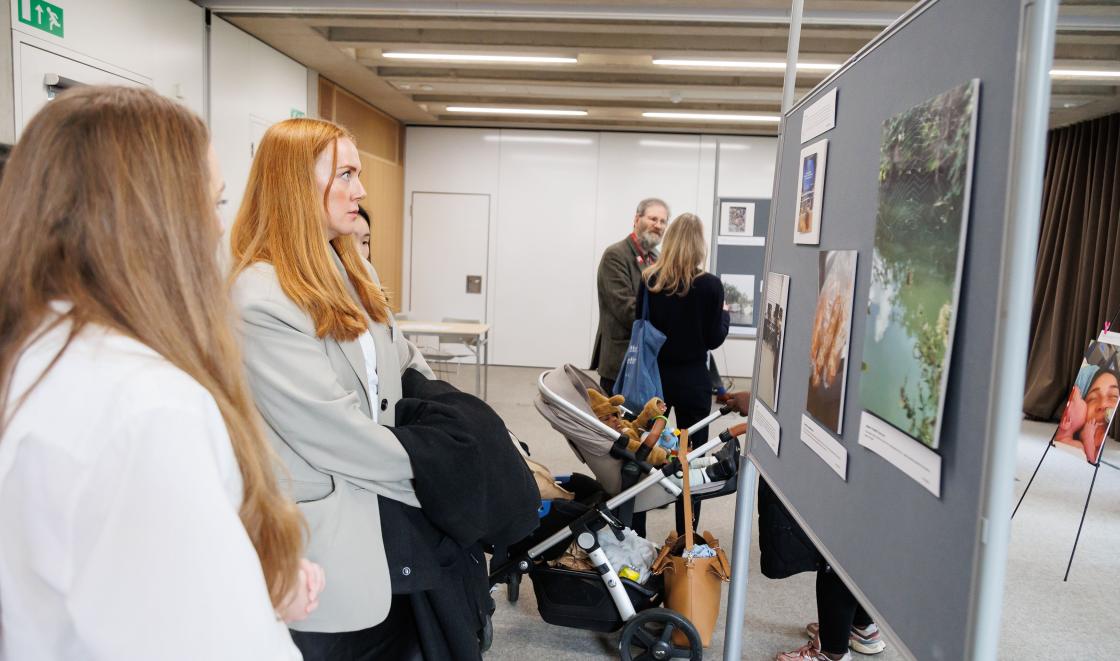 Attendees view the photo exhibition from the MORE project