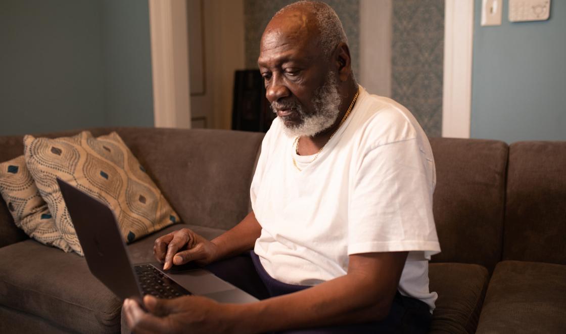 Elderly black man using laptop photo by Tolu Bamwo